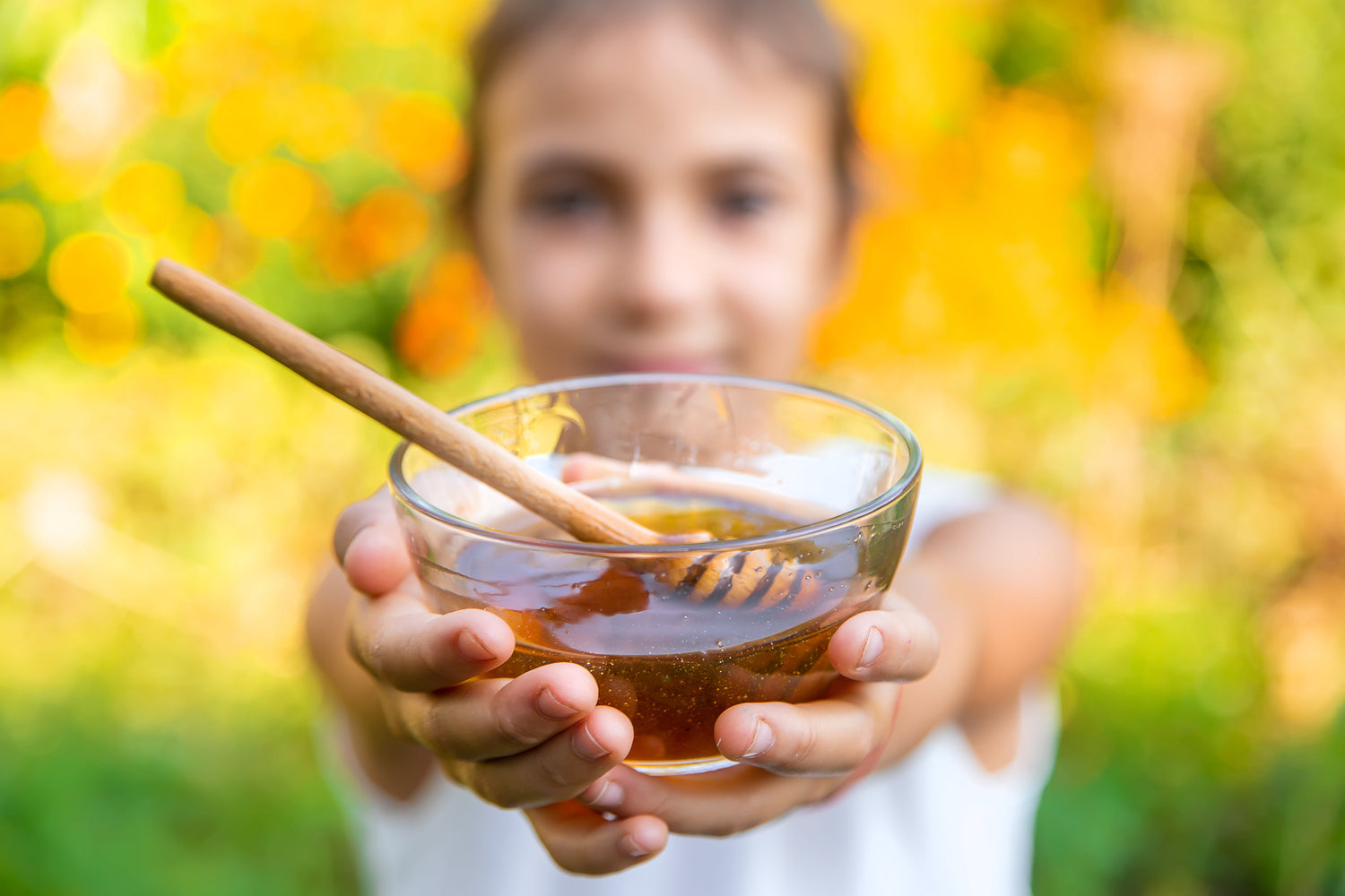 Child holding a bowl of honey